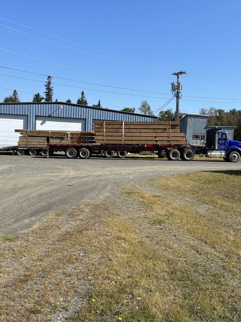 Tractor trailer transporting beams to a construction site.